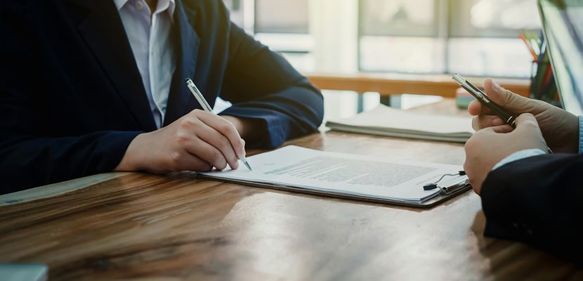 Dos personas firmando contrato de servicios de aseo para oficinas con Misión Servir