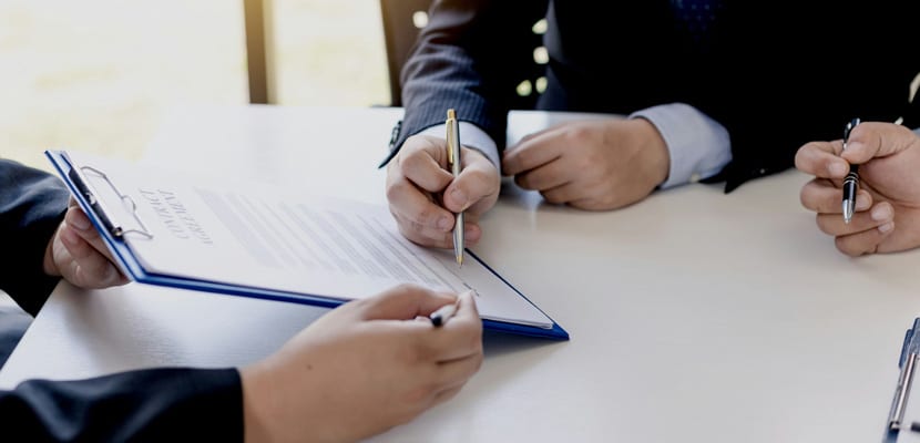 Plano cerrado de personas firmando contrato mostrando la manera correcta de elegir la empresa de servicios generales adecuada