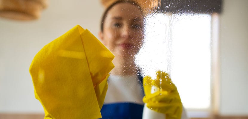 Mujer profesional de Misión Servir aplicando protocolo de limpieza y desinfección en un entorno laboral